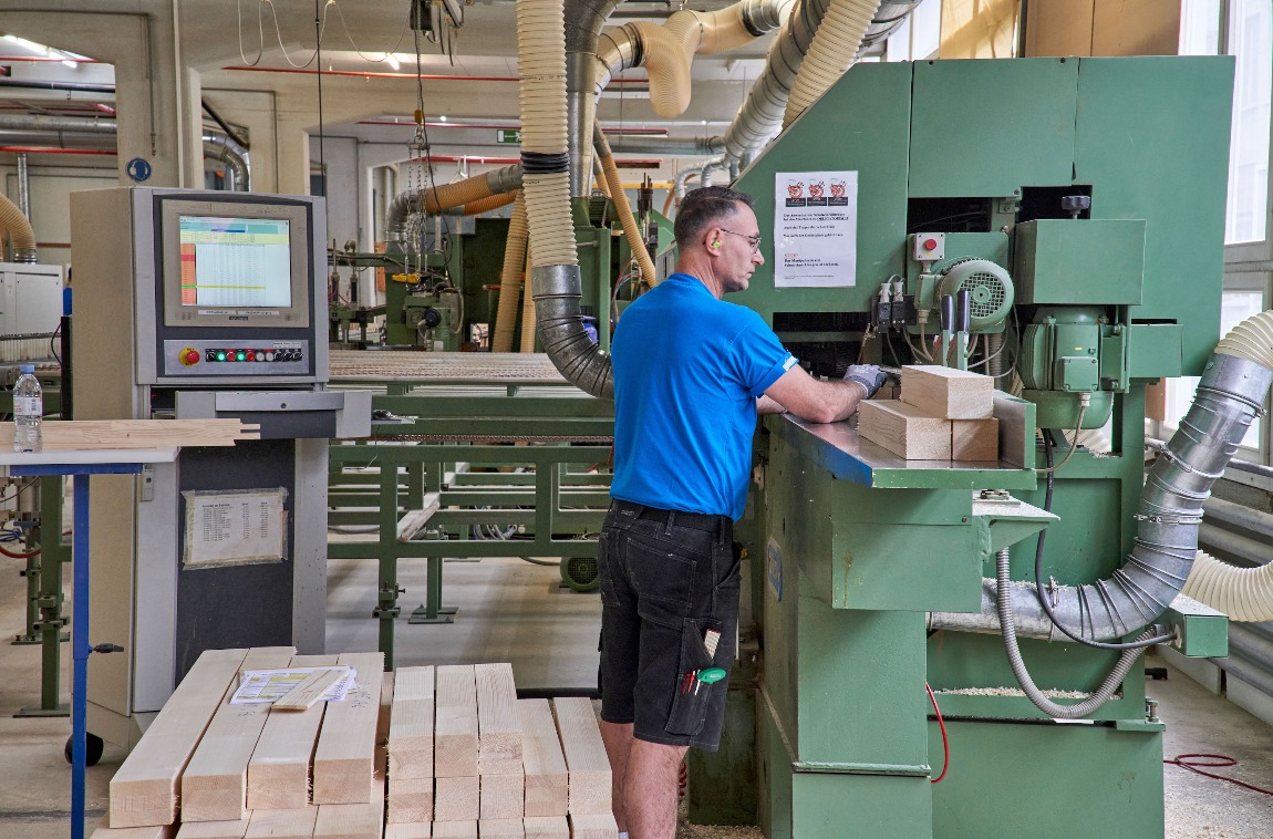 Der Schreiner schiebt die Klotzware in die Maschine, die ab den CAD-Daten die Fensterprofile dreidimensional fräst, inklusive der Zapfen-Schlitz-Ausfälzungen für die Eckverbindungen der Fensterrahmen. (Foto: Daniel Spehr 2021)